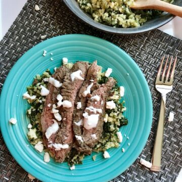Mediterranean Flank Steak with Kale & Feta Cauliflower Rice is a delicious Mediterranean-inspired recipe with a flavorful garlic-oregano-rubbed flank steak on top of delicious cauliflower “rice”. To finish it off, a cool and bright Lemon & Garlic Yogurt Sauce.