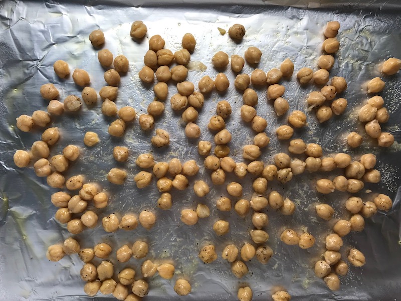 Chickpeas on pan spread out. Creamy Carrot Soup with Kale, Roasted Chickpeas and Thyme is a creamy, textured, easy-to-make soup! It's great as a starter, but hearty enough to be a meal with Kale and Chickpeas. Not only does this soup taste delicious, it's also incredibly healthy with vitamins, nutrients, fiber, and protein!