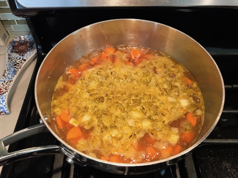 Broth with Carrots and onions boiling in pot on stove. Creamy Carrot Chickpea Soup with Kale, Roasted Chickpeas and Thyme is a creamy, textured, easy-to-make soup! It's great as a starter, but hearty enough to be a meal with Kale and Chickpeas. Not only does this soup taste delicious, it's also incredibly healthy with vitamins, nutrients, fiber, and protein!