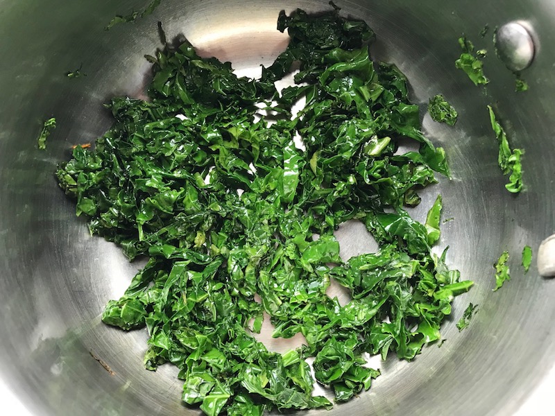 Kale cooked in pot. Creamy Carrot Soup with Kale, Roasted Chickpeas and Thyme is a creamy, textured, easy-to-make soup! It's great as a starter, but hearty enough to be a meal with Kale and Chickpeas. Not only does this soup taste delicious, it's also incredibly healthy with vitamins, nutrients, fiber, and protein!