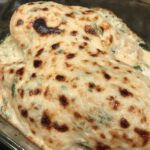 Creamy Garlic Parmesan Chicken browned on top in casserole dish.