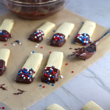 Cut Out Sugar Cookies dipped in chocolate and then topped with red, white, and blue star sprinkles.