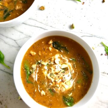 Creamy Tomato Soup in a white bowl on counter with spinach and sour cream on top. Second bowl in upper left corner. This recipe with Ground Chicken and Spinach is creamy and chunky and has a ton of deep flavor. AND it is healthy! It uses all white meat ground chicken that you cook until it is incredibly browned for some serious flavor. Then tomato paste adds the flavor back drop for the soup and a flour roux plus broth creates the amazing creaminess! Finally Spinach is your veggie boost.
