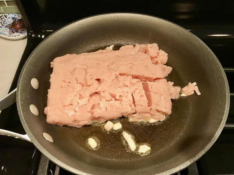 Raw Ground chicken cooking in a skillet for Ground Chicken Ragu.