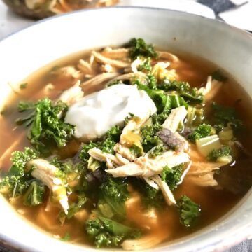 Chicken Tortilla Soup with sour cream on top in bowl on counter