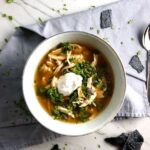 Chicken Tortilla Soup in a bowl with sour cream on top and tortilla chips on side. It's quick, it's easy, it's delicious AND...it's an all-in-one balanced dish because I have added KALE! Done in 30 minutes!