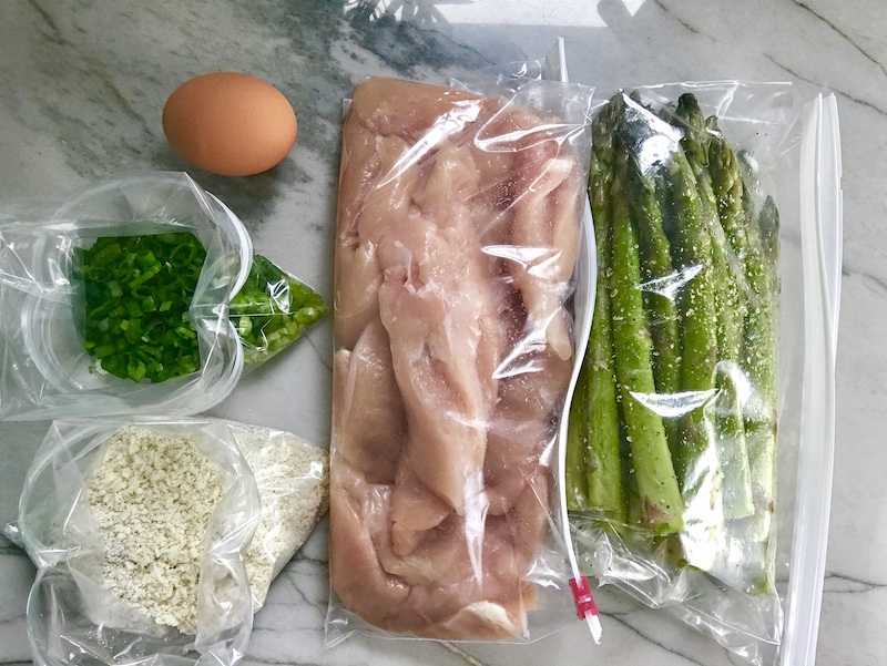 chicken, asparagus, breadcrumbs, scallions, and egg all in baggies on counter