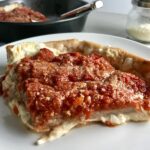 Slice of Chicago Style pizza with tomatoes on top.This Chicago Style Pizza is a lighter and healthier version, but still AMAZING! It still has all of the gooey mozzarella cheese, but uses homemade turkey Italian Sausage, that's so delicious!