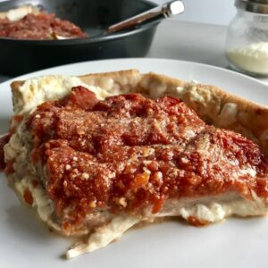 Slice of Chicago Style pizza with tomatoes on top.This Chicago Style Pizza is a lighter and healthier version, but still AMAZING! It still has all of the gooey mozzarella cheese, but uses homemade turkey Italian Sausage, that's so delicious!