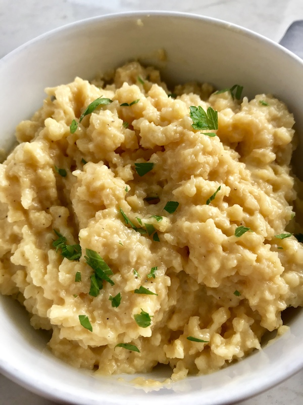 Welcome to my new favorite comfort food with a healthy twist: Cheesy Cauliflower Rice. If Mac and Cheese met Cauliflower, fell in love and had a baby, it would be this Cheesy Cauliflower Rice. This recipe is so simple with just the flavors from the cauliflower - plus a few other things to help it come together.