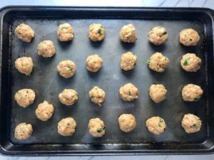 Raw Moroccan raw turkey meatballs on a sheet pan to go into Pita Bread Sandwiches Recipe.