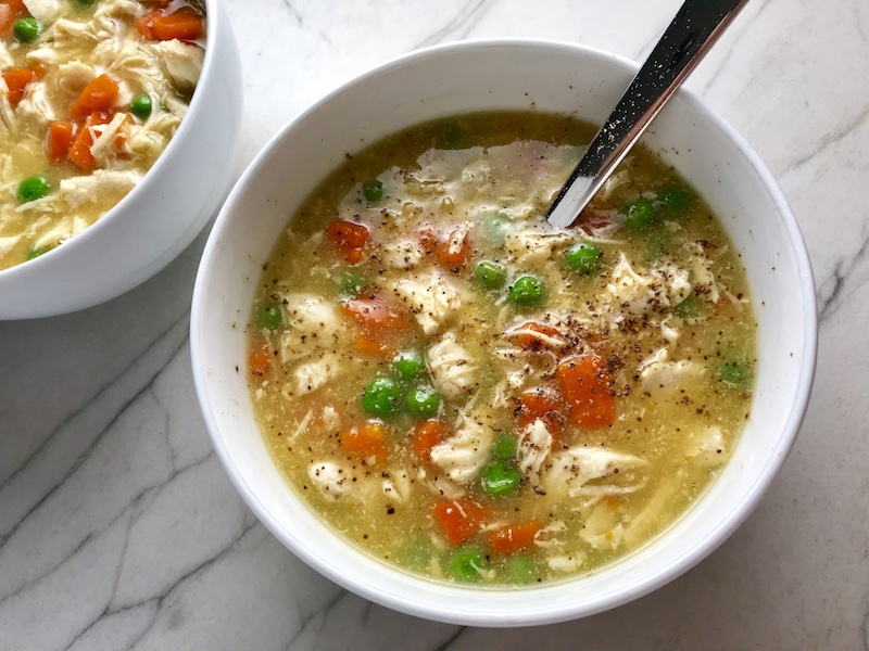 5-Ingredient Chunky Chicken Vegetable Soup in a bowl on counter with spoon in bowl. It's creamy (but there is no dairy!) and chunky, and delicious! With loads of chicken, carrots, and peas.