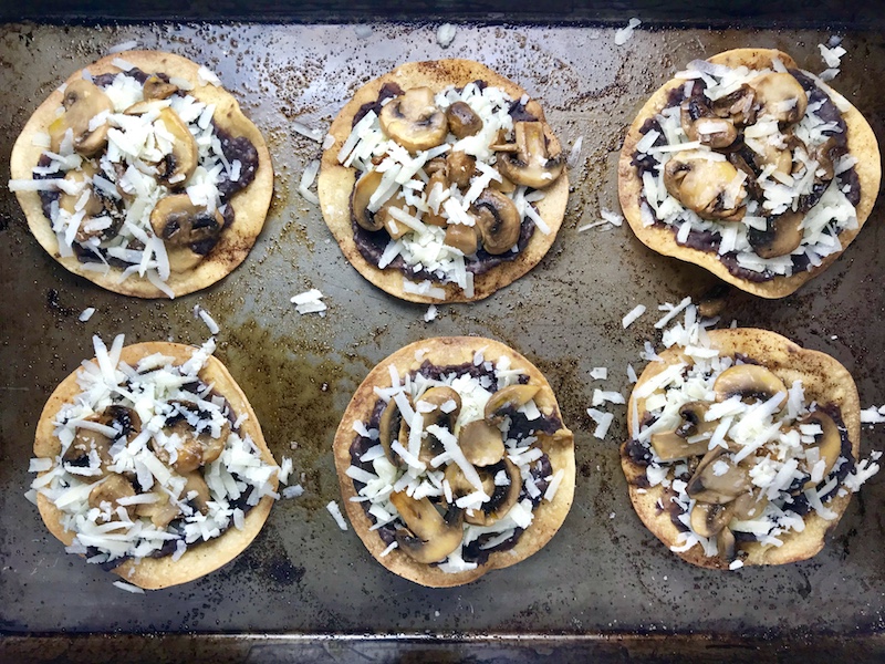 Mushroom and Black Bean Tostadas with Manchego Cheese, and Cilantro Lime Cream are crazy good! The tortillas are baked until crunchy, then topped with homemade refried black beans, nutty aged Manchego Cheese, sautéed mushrooms, and then baked until the cheese is melted. Top with cool cilantro lime cream, crisp radishes, and fresh cilantro. Simple, Gluten-Free, Vegetarian, Delicious!