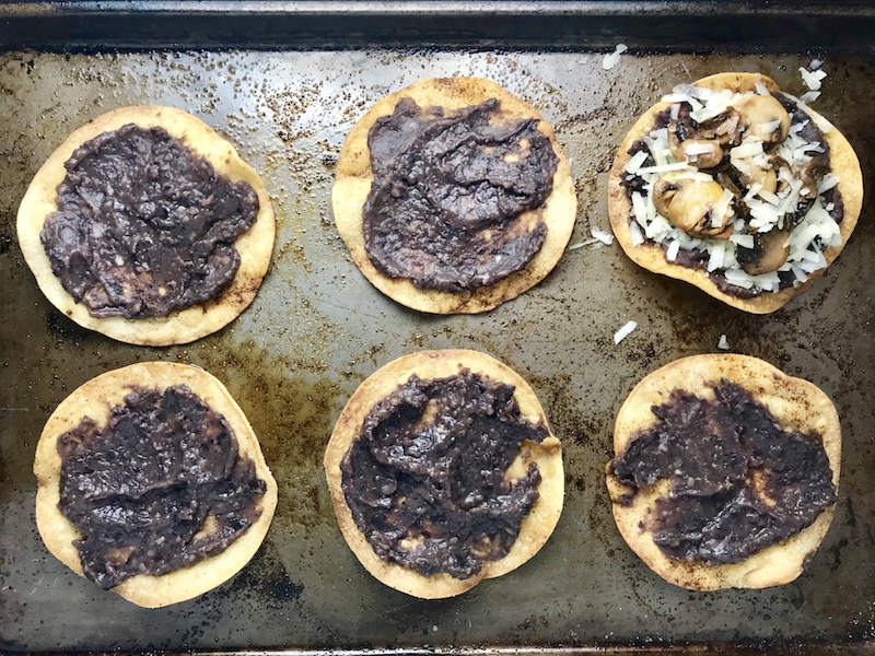Mushroom and Black Bean Tostadas with Manchego Cheese, and Cilantro Lime Cream are crazy good! The tortillas are baked until crunchy, then topped with homemade refried black beans, nutty aged Manchego Cheese, sautéed mushrooms, and then baked until the cheese is melted. Top with cool cilantro lime cream, crisp radishes, and fresh cilantro. Simple, Gluten-Free, Vegetarian, Delicious!