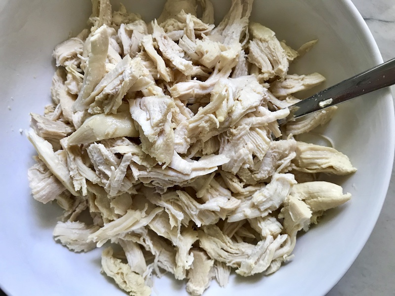 Shredded chicken on plate for Asian Noodle Bowl recipe with ramen noodles.