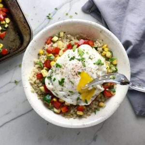 This 5-ingredient Sunny Quinoa with Fried Egg & Veggie Medley is simple, but incredible. The Veggie Medley is a trifecta of red pepper, zucchini, and sweet corn that are roasted on a sheet pan. Then on top of it all is a salty fried egg with a runny yoke that oozes out to bring a deep creaminess to the entire dish.
