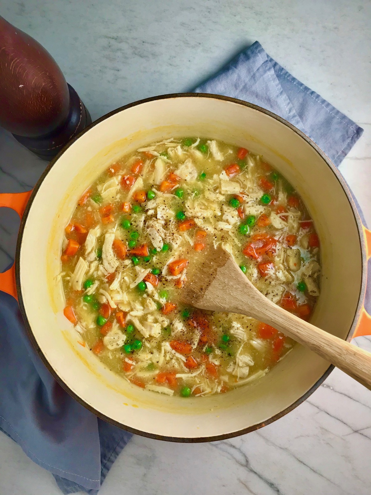 5-Ingredient Creamy Chicken and Vegetable Soup in a pot on counter with wooden spoon.