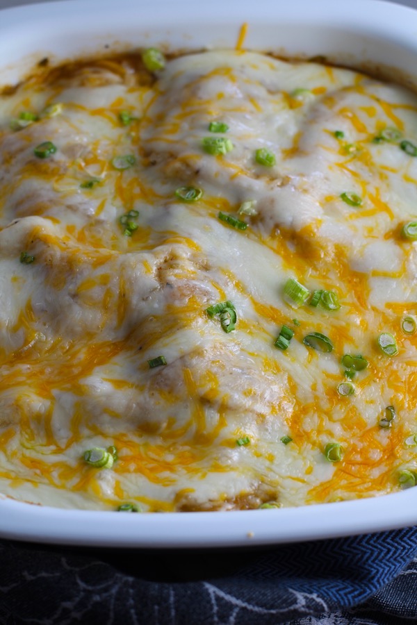 White Enchilada Casserole with Chicken & Veggies is hearty, cheesy, delicious, & easy because everything is layered in one dish. #healthydinner #familydinners #chickendinners #chickenrecipes