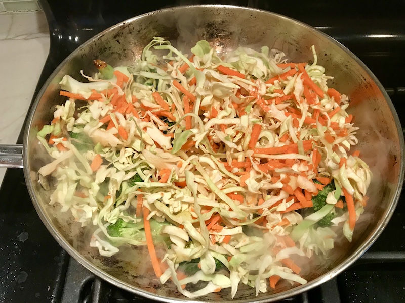 Cabbage, carrots, and broccoli cooking in pan for Peanut Teriyaki Chicken and Broccoli stir fry with rice noodles.