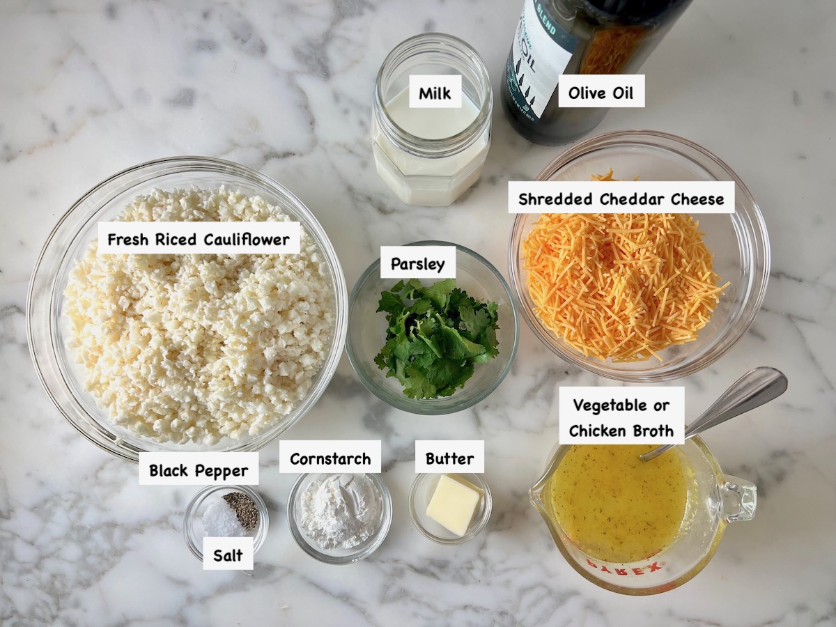 Ingredients prepped and measured out in bowls on counter with labels overlayed on the picture for Cheesy Cauliflower Rice Recipe.