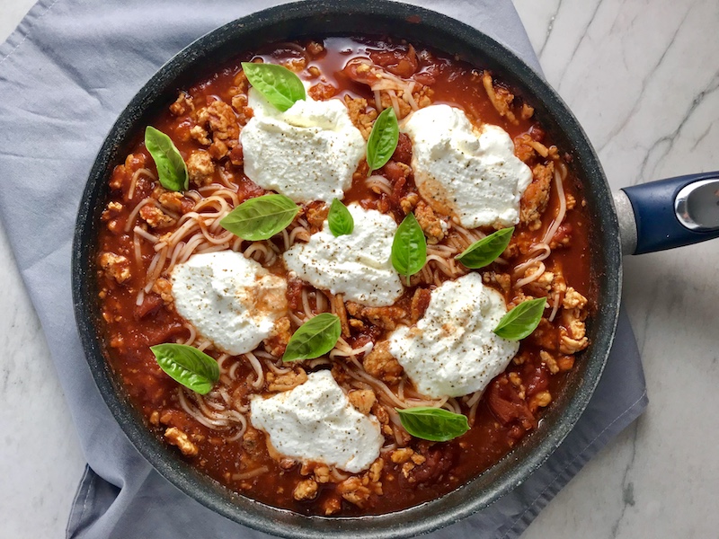 This Skillet Ground Chicken Tomato Sauce with Ricotta is a delicious and simple one pan meal. Ground chicken is seared until it gets a super browned, flavorful crust. Then garlic, vegetable broth and tomatoes are added and cooked down into a delightful sauce that really lets the tomato shine with a meaty bite from the chicken. After pasta is mixed in, creamy Ricotta Cheese is dolloped on and fresh basil added to garnish. It's perfection! Bellissimo!