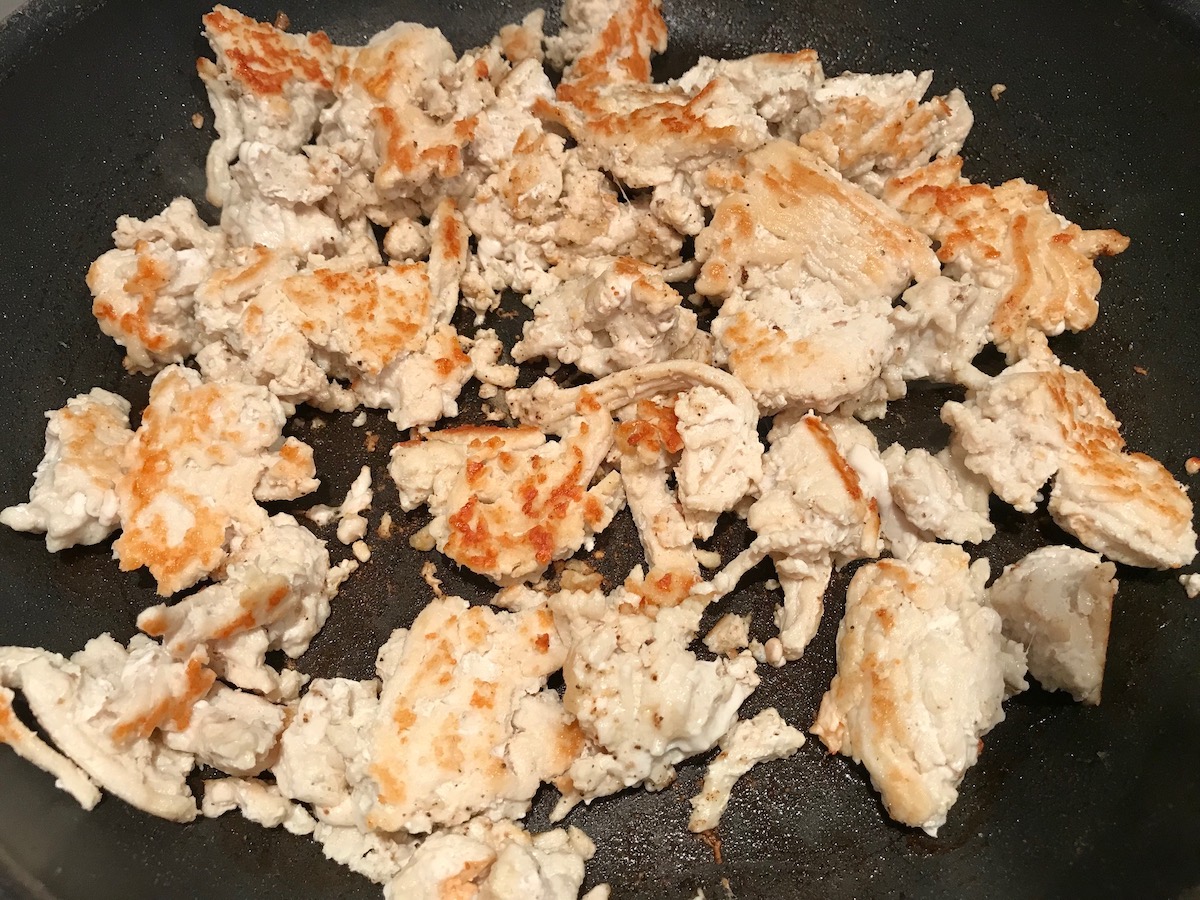 Ground chicken being seared and browned in a frying pan for the Tomato Chicken Ricotta Pasta recipe.