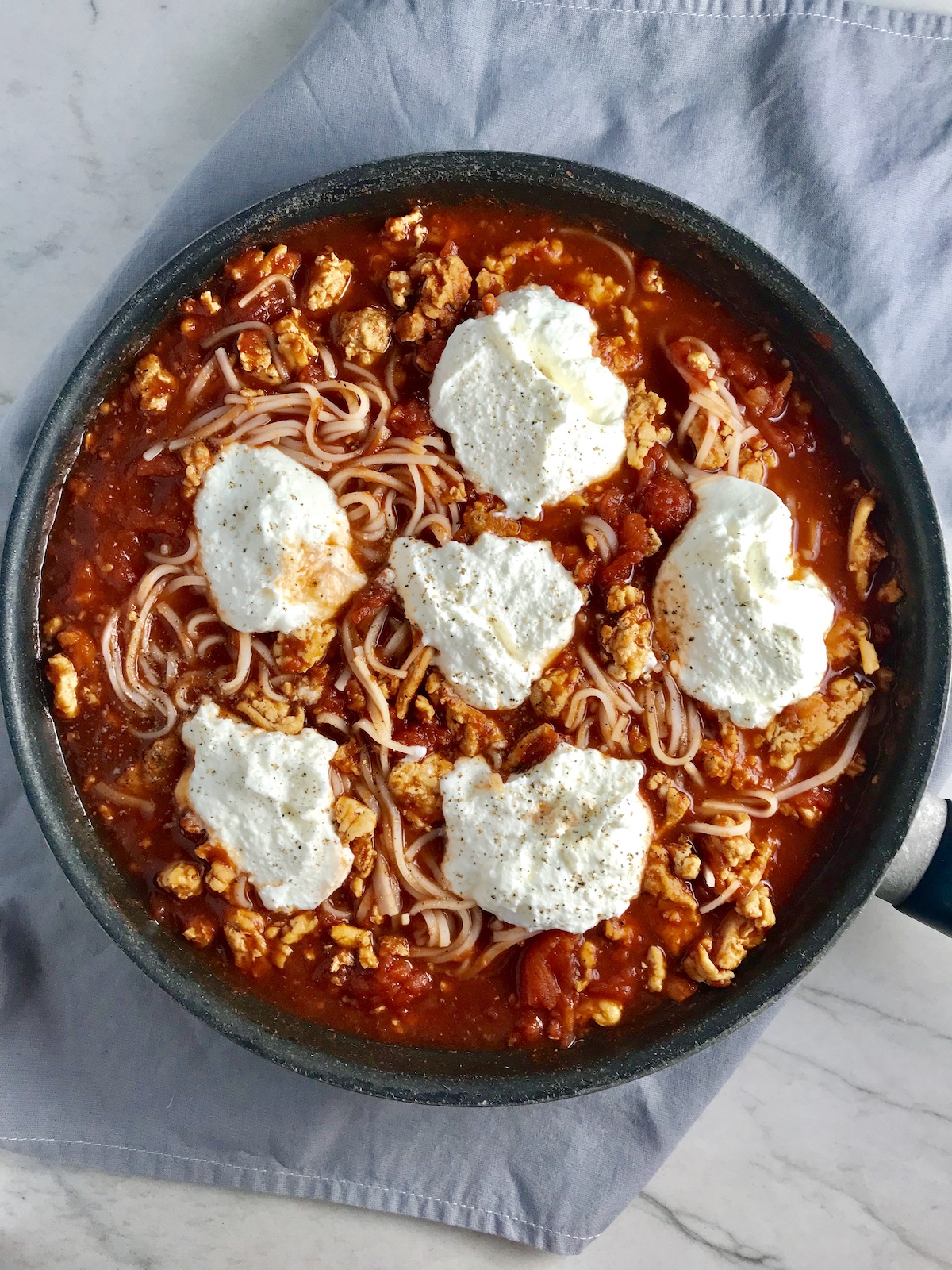 Tomato Chicken Ricotta Pasta in a skillet on counter.