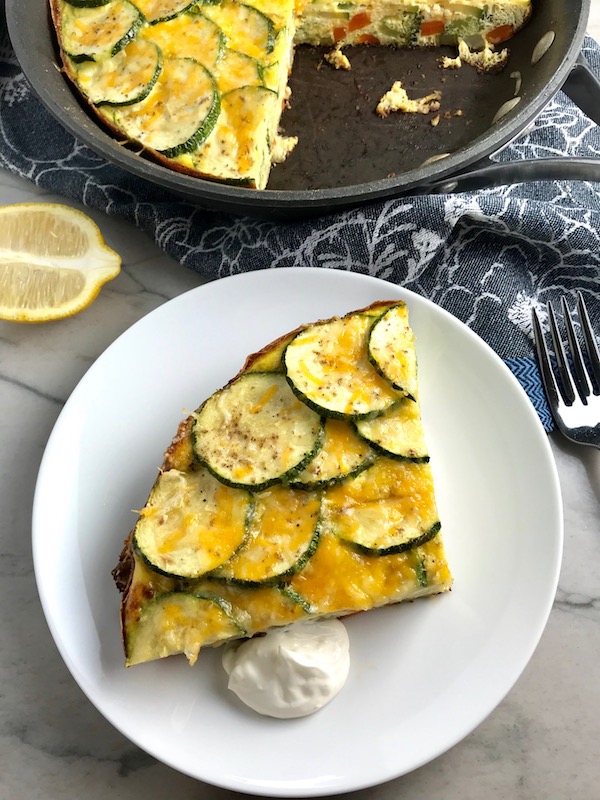 Vegetable Frittata with Lemon Crema is an easy weeknight dinner, quick breakfast, or weekend brunch recipe! This Vegetable Frittata is thick and hearty with lots of flavors and textures from the veggies, but is also light and creamy from the eggs and cheese. It's loaded with healthy veggies, is gluten free, and super EASY to make and to clean up after.