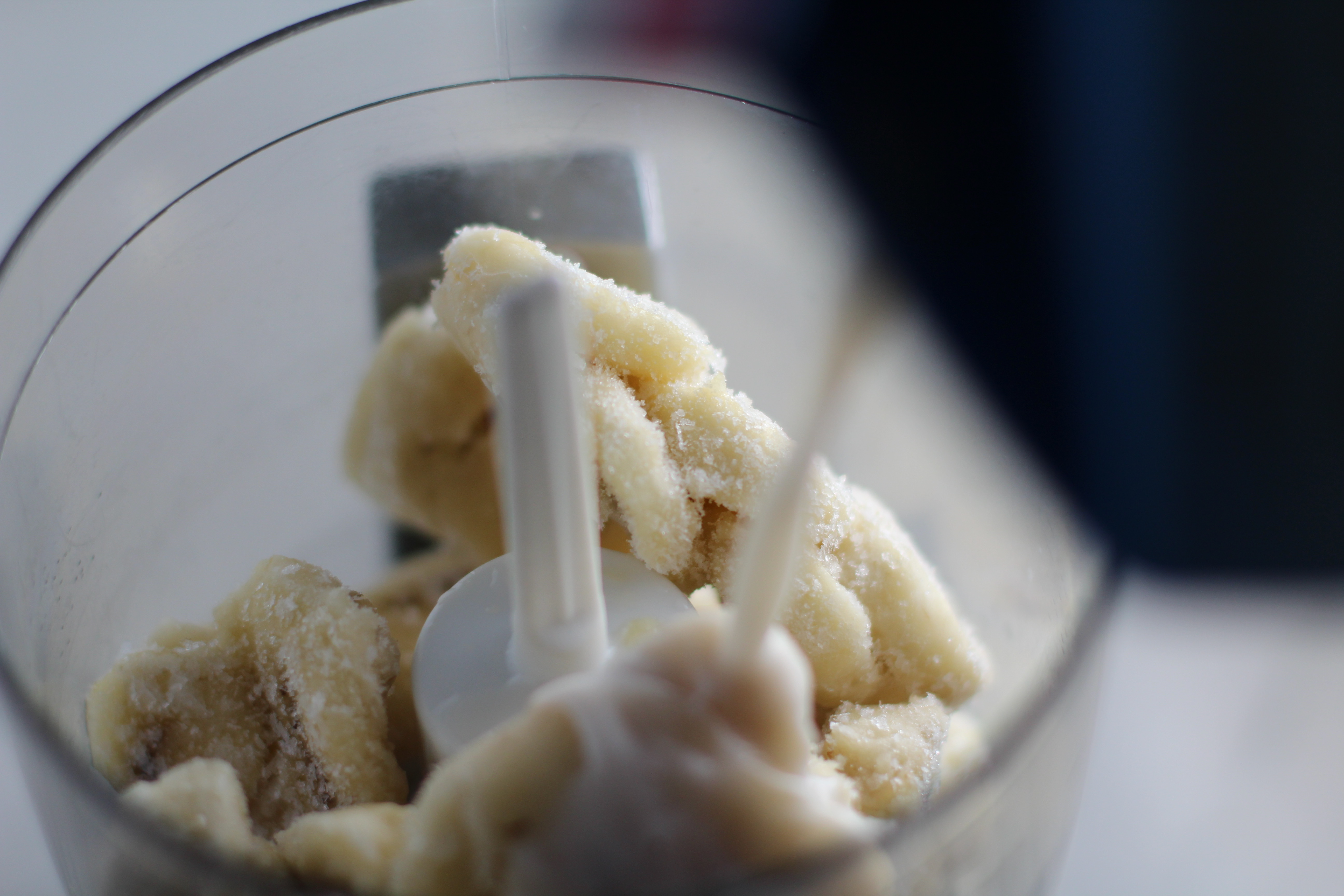 Pouring milk over frozen Bananas in a food processor. Banana Ice Cream is literally just 2 ingredients, Frozen Bananas and Almond Milk. Add in crunchy Graham Crackers as the 3rd ingredient and you have a delicious healthy Banana Ice Cream Sandwich! If you have never tried banana ice cream, you are in for a treat! It tastes just like soft serve ice cream.