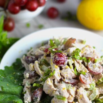 Lemon Basil Chicken Salad with Grapes on a plate on counter with grapes and lemon in background. This recipe is simple, but the taste is anything but simple. It has layers of flavors and textures. You get the hearty texture of the chicken, brightness from the lemon, the fresh and fragrant basil, a slight bite from the onion, and a huge juicy burst of sweetness from the grapes.
