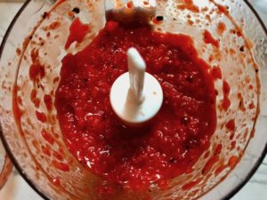 Roasted Red Peppers blended in a food processor for Roasted Red Pepper Gazpacho recipe from talkingmeals.com.