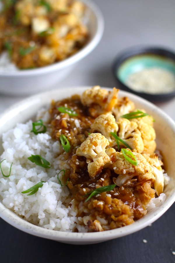 This Korean Rice Bowl on counter with Rice, Lentils and Cauliflower. This recipe is da bomb, exploding with flavor! The rice soaks up the sauce, which gives you a nutty, salty flavor from sesame oil and soy sauce, a warm and zesty kick from ginger and garlic, and sweetness from honey to balance it all out. Lentils and cauliflower give a meaty bite.
