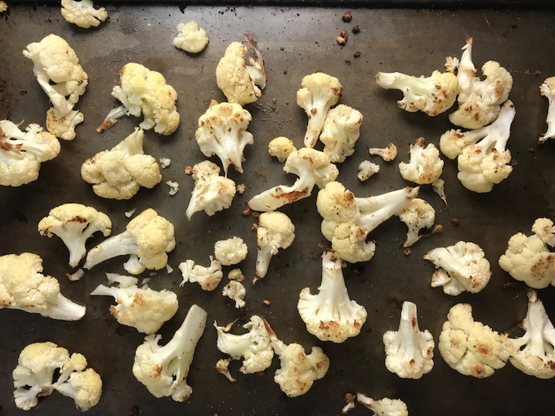 Roasted Cauliflower on pan for Korean Rice Bowl with Lentils and Cauliflower recipe, which is da bomb, exploding with flavor! The rice soaks up the sauce, which gives you a nutty, salty flavor from sesame oil and soy sauce, a warm and zesty kick from ginger and garlic, and sweetness from honey to balance it all out. Lentils and cauliflower give a meaty bite.