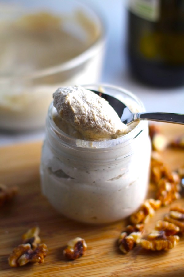 Walnut Cream Sauce in a jar on cutting board with walnuts next to it. Bowl in back. This recipe has ricotta cheese and parmesan with spinach and is thick, rich, nutty, and creamy. It's inspired by the traditional Italian Walnut Sauce from the North-Western Italy, Liguria Region, but my Walnut Sauce recipe adds even more decadence with creamy ricotta and more nutty parmesan cheese.