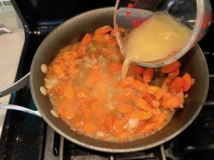 Chicken Broth being poured over carrots and onions in skillet. Smothered Pork Chop Casserole is a true midwestern comfort dish with layers of vegetables and meaty pork chops smothered in a creamy sauce and cheese. The pork chops in this delicious casserole are left whole so that you get an entire portion dripping in goodness in one scoop.