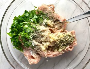 Parsley, garlic, fennel seed, salt, pepper, raw ground chicken in bowl. These Hanky Panky Canapes are the BEST Party Appetizers around! They cheesy, meaty, and absolutely delicious. Ground Beef is mixed with Homemade Chicken Sausage and then combined with lots of cheese until its a creamy addictive pot of goodness. Then it is scooped on top of bread, toasts, or crackers