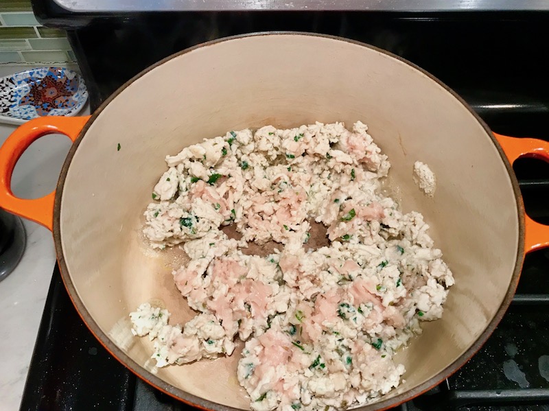 Cooking Chicken Sausage Meat in pot. These Hanky Panky Canapes are the BEST Party Appetizers around! They cheesy, meaty, and absolutely delicious. Ground Beef is mixed with Homemade Chicken Sausage and then combined with lots of cheese until its a creamy addictive pot of goodness. Then it is scooped on top of bread, toasts, or crackers