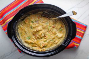 Chipotle Chicken Enchilada Stew cooked in a slow cooker pot. This is one of my Prepped Freezer Meal recipes and it's creamy, cozy, hearty, cheesy, and slightly spicy. All ingredients freeze raw, thaw, then cook in the slow cooker or in the oven. It's a stew because it's thick and hearty with bites of chicken, carrots, onion, chipotle peppers, cumin, garlic and tortilla chips that melt down to thicken this delicious stew.
