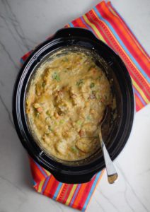 Chipotle Chicken Enchilada Stew cooked in a slow cooker pot. This is one of my Prepped Freezer Meal recipes and it's creamy, cozy, hearty, cheesy, and slightly spicy. All ingredients freeze raw, thaw, then cook in the slow cooker or in the oven. It's a stew because it's thick and hearty with bites of chicken, carrots, onion, chipotle peppers, cumin, garlic and tortilla chips that melt down to thicken this delicious stew.