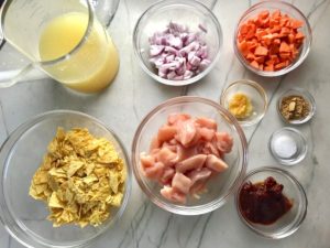 All Ingredients in bowls on counter for Chipotle Chicken Enchilada Stew. It's one of my Prepped Freezer Meal recipes and it's creamy, cozy, hearty, cheesy, and slightly spicy. All ingredients freeze raw, thaw, then cook in the slow cooker or in the oven. It's a stew because it's thick and hearty with bites of chicken, carrots, onion, chipotle peppers, cumin, garlic and tortilla chips that melt down to thicken this delicious stew.