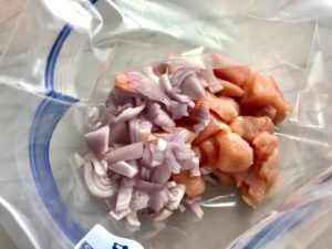 Add Onions to cut chicken in freezer bag for Chipotle Chicken Enchilada Stew. It is one of my Prepped Freezer Meal recipes and it's creamy, cozy, hearty, cheesy, and slightly spicy. All ingredients freeze raw, thaw, then cook in the slow cooker or in the oven. It's a stew because it's thick and hearty with bites of chicken, carrots, onion, chipotle peppers, cumin, garlic and tortilla chips that melt down to thicken this delicious stew.