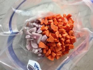 Diced onions and carrots in freezer bag for Chipotle Chicken Enchilada Stew. It is one of my Prepped Freezer Meal recipes and it's creamy, cozy, hearty, cheesy, and slightly spicy. All ingredients freeze raw, thaw, then cook in the slow cooker or in the oven. It's a stew because it's thick and hearty with bites of chicken, carrots, onion, chipotle peppers, cumin, garlic and tortilla chips that melt down to thicken this delicious stew.