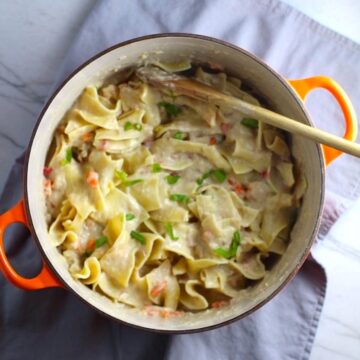 Cheesy Tuna Noodle Casserole Recipe in a pot on counter. This is a creamy and delicious comfort dish with tuna and noodles and a surprise pop of sweet from Pimiento.  This easy recipe is completely from scratch (no canned soup here!) but I can promise you it's so easy and only takes 30 minutes because it's a Casserole that you can make entirely on the stove top!