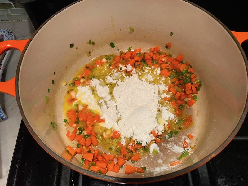 Flour added to diced carrots and scallions in pot for Stove top Easy Tuna Casserole. This is a creamy and delicious comfort dish with tuna and noodles and a surprise pop of sweet from Pimiento. This easy recipe is completely from scratch (no canned soup here!) but I can promise you it's so easy and only takes 30 minutes because it's a Casserole that you can make entirely on the stove top!
