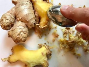 spoon scraping skin off of whole ginger root for Moroccan Chicken Chili with Chickpeas is loaded with comforting and healthy ingredients and spices. You get warmth from Ginger, Turmeric, Garlic, and Coriander. Then tons of hearty flavor from browned ground chicken and Shallots. And creaminess from the Carrots and Chickpeas. You can make it ahead and freeze it until you are ready to cook it!