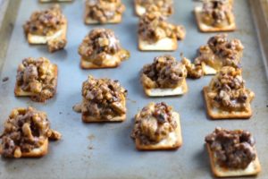Hanky Panky Canapes cooked on sheet pan. These Hanky Panky Canapes are the BEST Party Appetizers around! They cheesy, meaty, and absolutely delicious. Ground Beef is mixed with Homemade Chicken Sausage and then combined with lots of cheese until its a creamy addictive pot of goodness. Then it is scooped on top of bread, toasts, or crackers