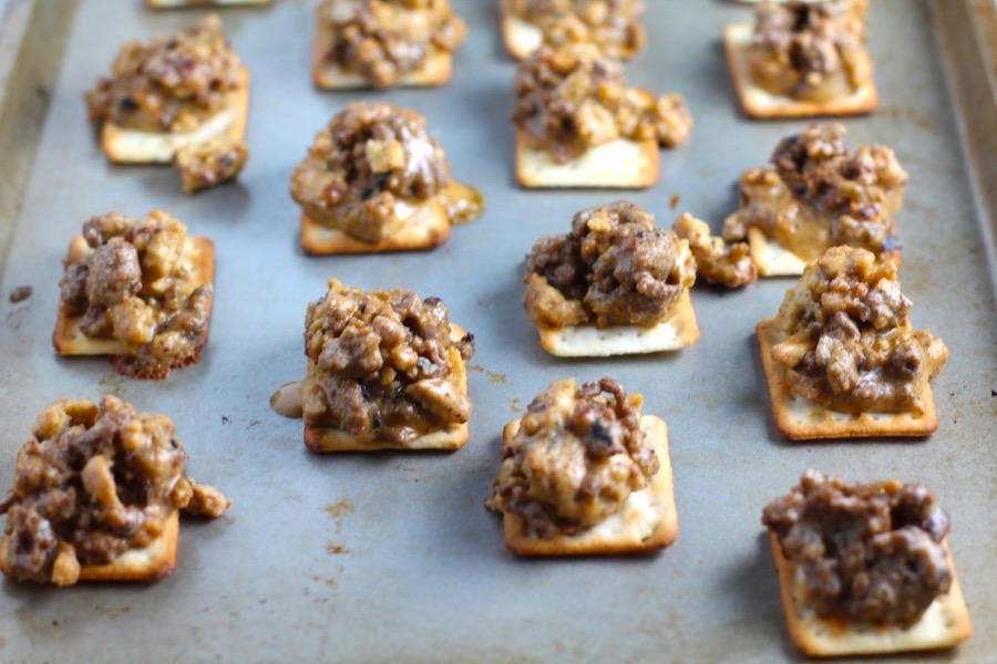 Hanky Panky Canapes cooked on sheet pan. These Hanky Panky Canapes are the BEST Party Appetizers around! They cheesy, meaty, and absolutely delicious. Ground Beef is mixed with Homemade Chicken Sausage and then combined with lots of cheese until its a creamy addictive pot of goodness. Then it is scooped on top of bread, toasts, or crackers
