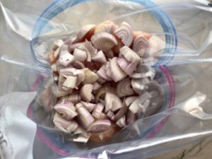 Chopped Shallots added to bag with chicken for Freezer Hoisin Chicken with Red Peppers, Carrots, Onions, Ginger, and Soy sauce is delicious and so easy to make. You get sweet and savory all in one dish and it's perfect for kids because it's sweet, not spicy at all. Just freeze ahead, thaw, then cook on a sheet pan!