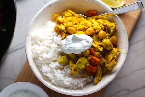 Moroccan Chicken Chili in bowl over white rice with a dollop of Cilantro Lime Yogurt on top. Moroccan Chicken Chili with Chickpeas is loaded with comforting and healthy ingredients and spices. You get warmth from Ginger, Turmeric, Garlic, and Coriander. Then tons of hearty flavor from browned ground chicken and Shallots. And creaminess from the Carrots and Chickpeas. You can make it ahead and freeze it until you are ready to cook it!