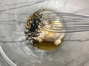 Sesame dressing ingredients in bowl for Asian Lettuce Wraps. They are a fantastic way to use leftover Turkey or Chicken transforming it with new delicious flavors and textures. The turkey is stir fried with carrots, red pepper, and brussel sprouts in a flavorful ginger, garlic, & sesame sauce. It's layered in lettuce wraps with rice and a cool, crunchy purple cabbage sesame slaw. Serve with a Garlic Honey Soy Sauce....YUM!!!